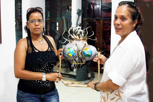 Teresita Gómez (derecha) y Yuray Toletino con una obra de Osneldo García Díaz, premiado en 2001.